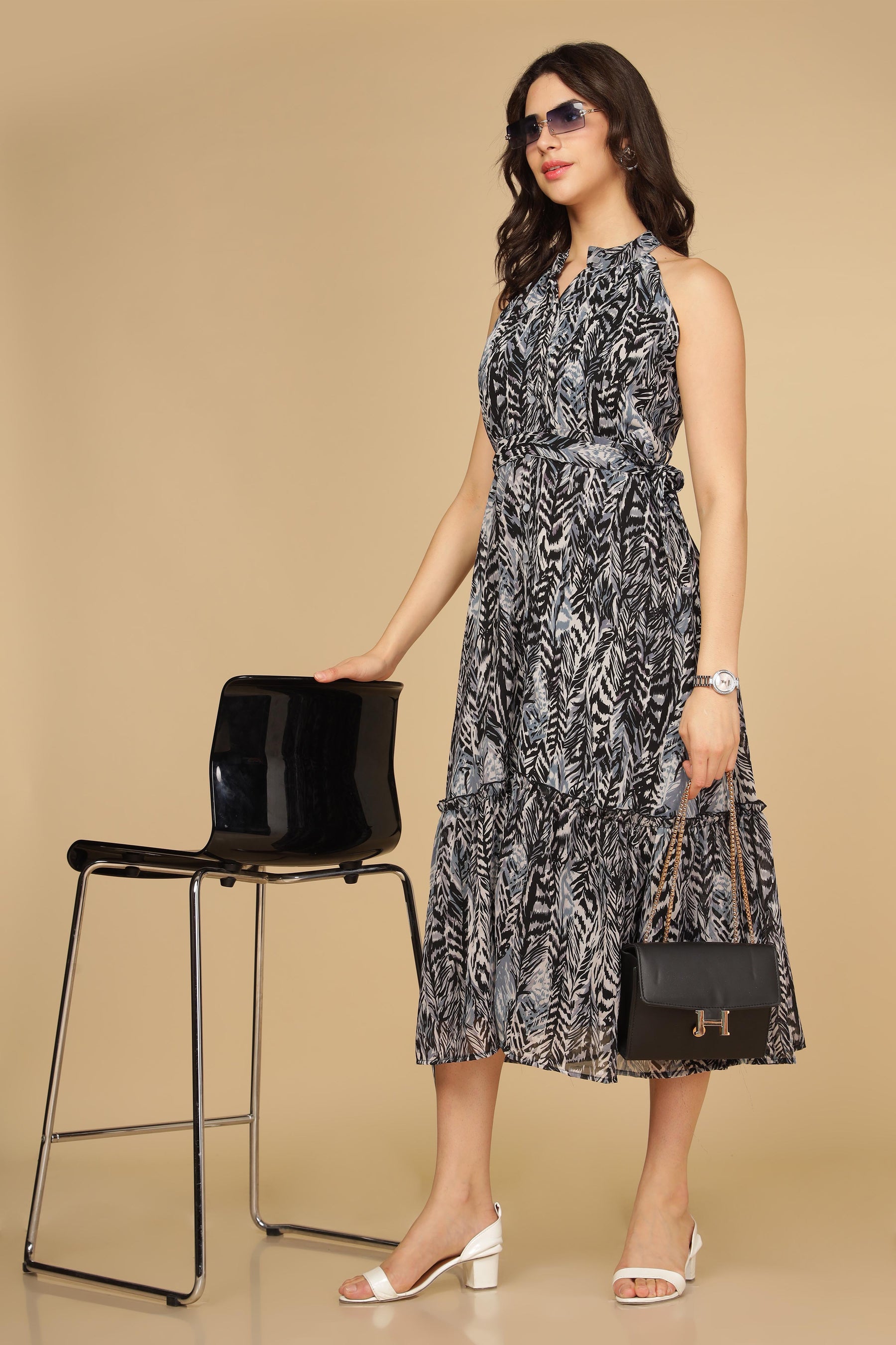 Elegant black halter neck maxi dress styled with accessories.