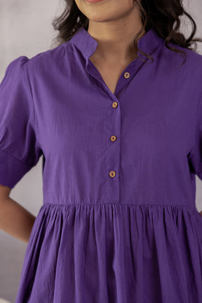 Purple cotton midi dress with button detail and pleated design.