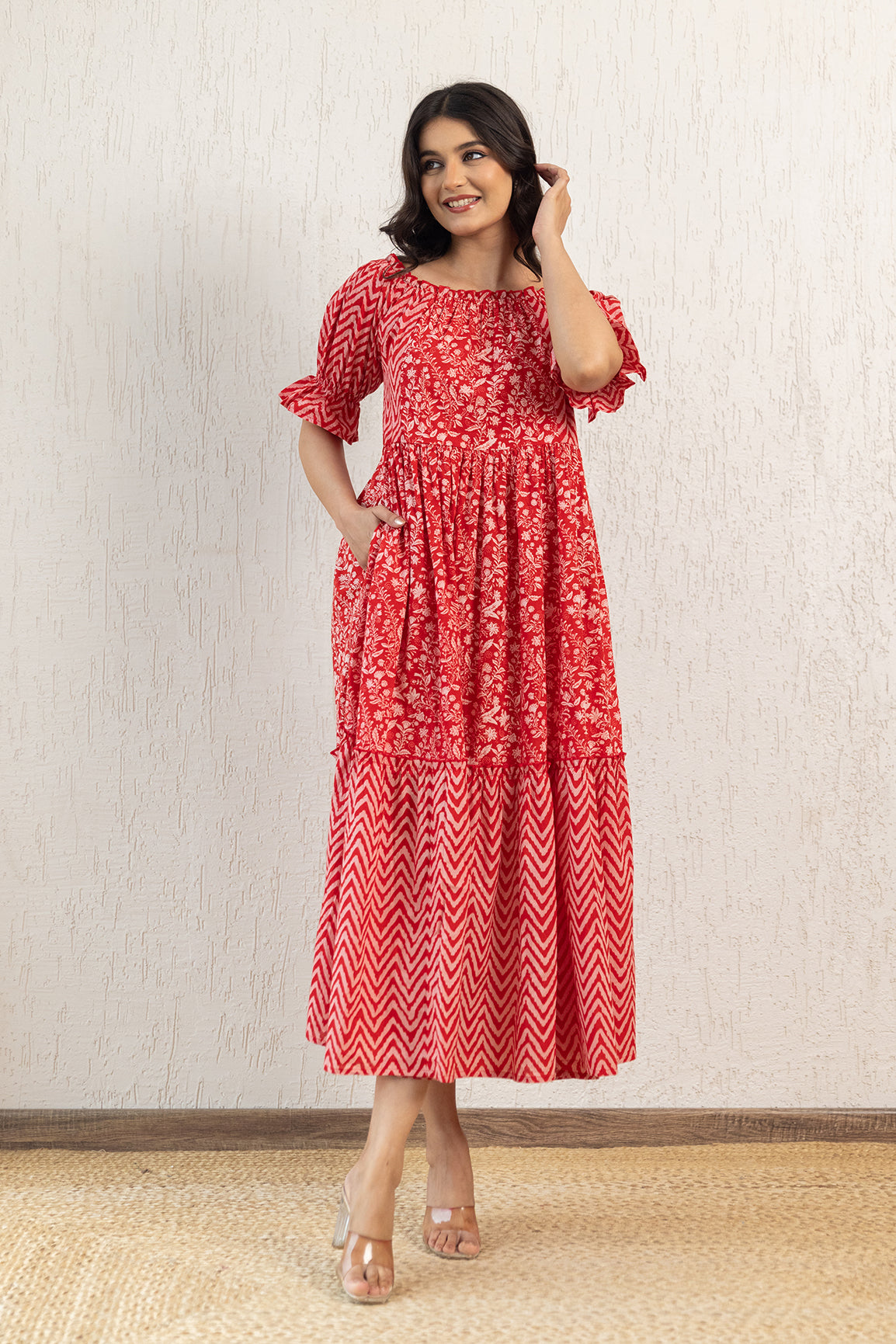 Red off-shoulder cotton maxi dress with floral design and puff sleeves.