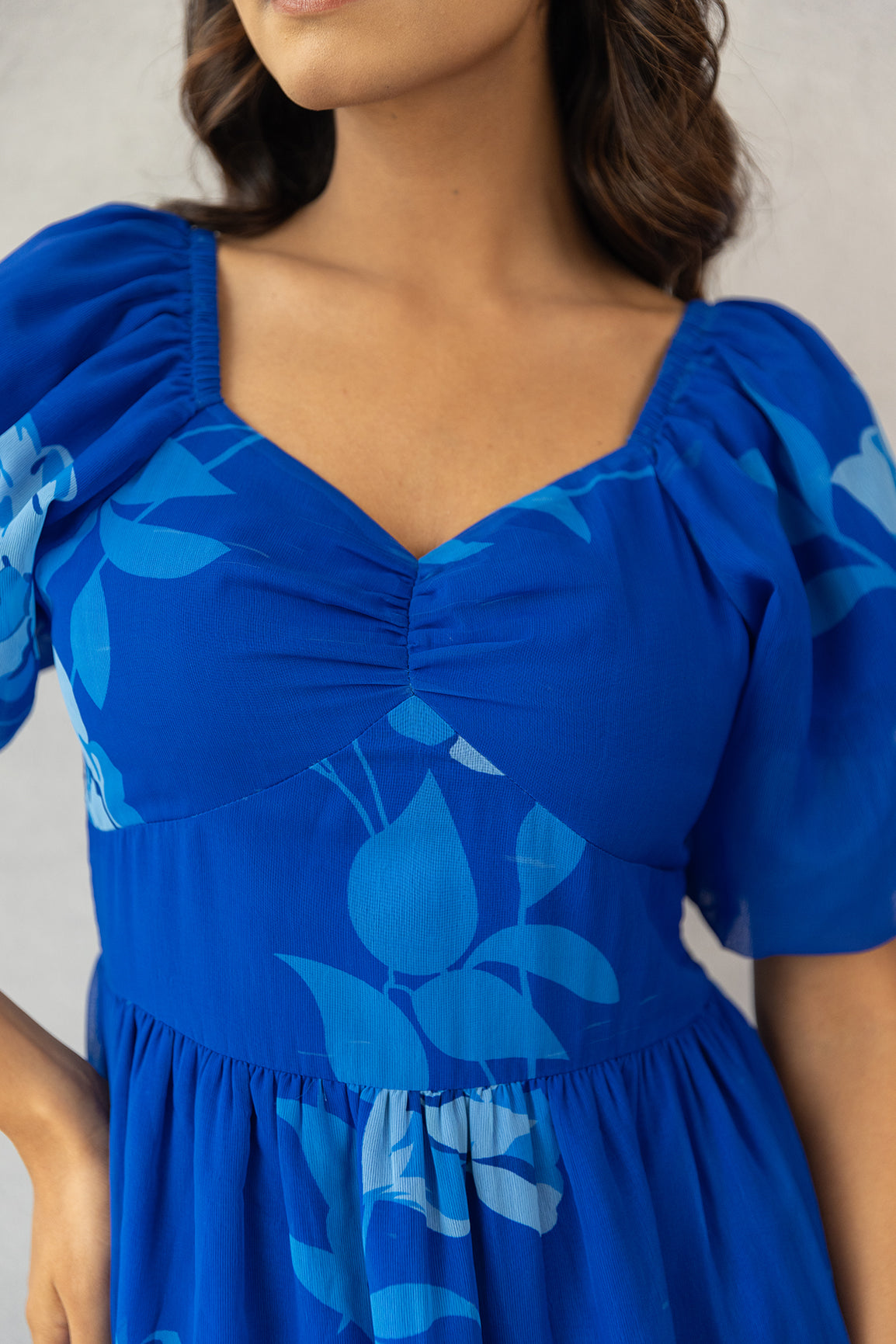 Royal blue maxi dress with floral prints and puff sleeves.