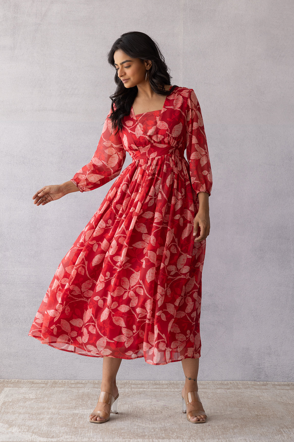 Model wearing a dark red chiffon maxi dress with floral pattern.