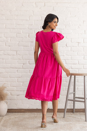 Bright pink Schifilli cotton dress with flutter sleeves, stylish back view.