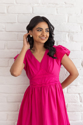 Smiling woman in a stylish pink Schifilli cotton dress.