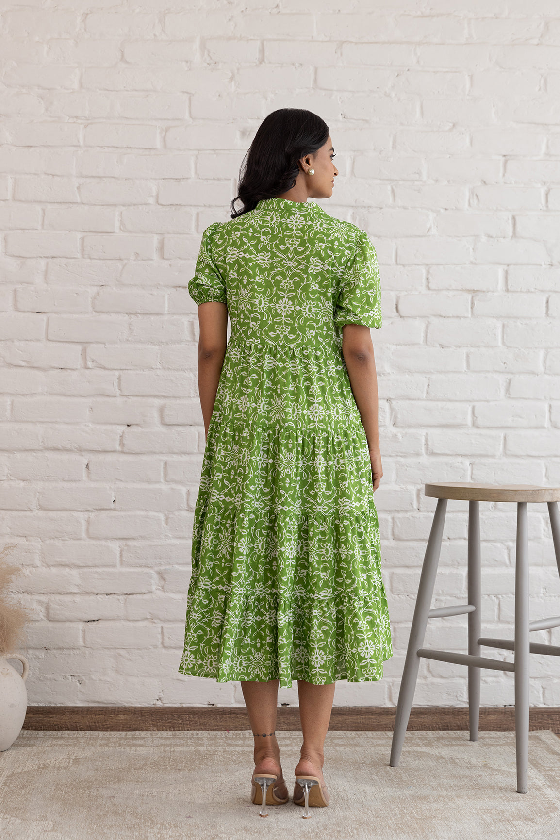 Back view of a woman in a green cotton maxi dress.