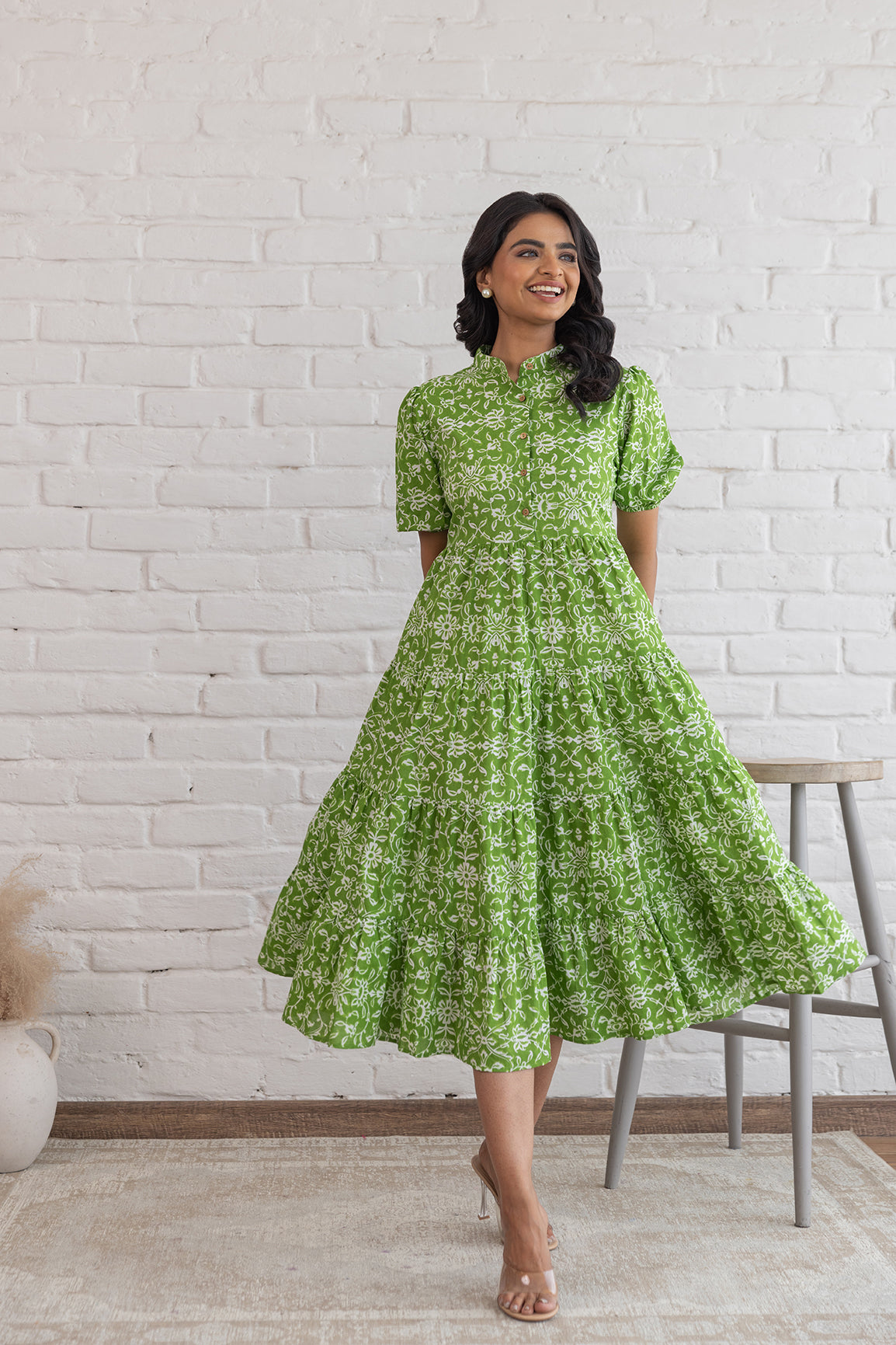 Elegant green cotton maxi dress with floral print in a stylish setting.