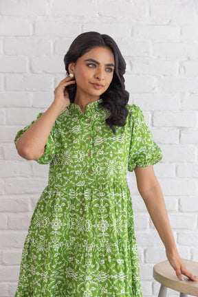 Elegant green cotton maxi dress with floral print and puff sleeves.