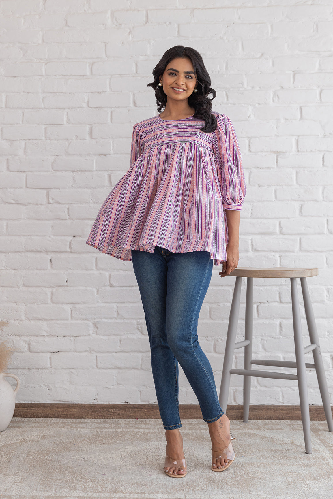 Stylish pink striped cotton top paired with blue jeans.