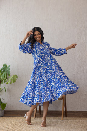 Woman wearing a blue and white cotton maxi dress, dancing joyfully.