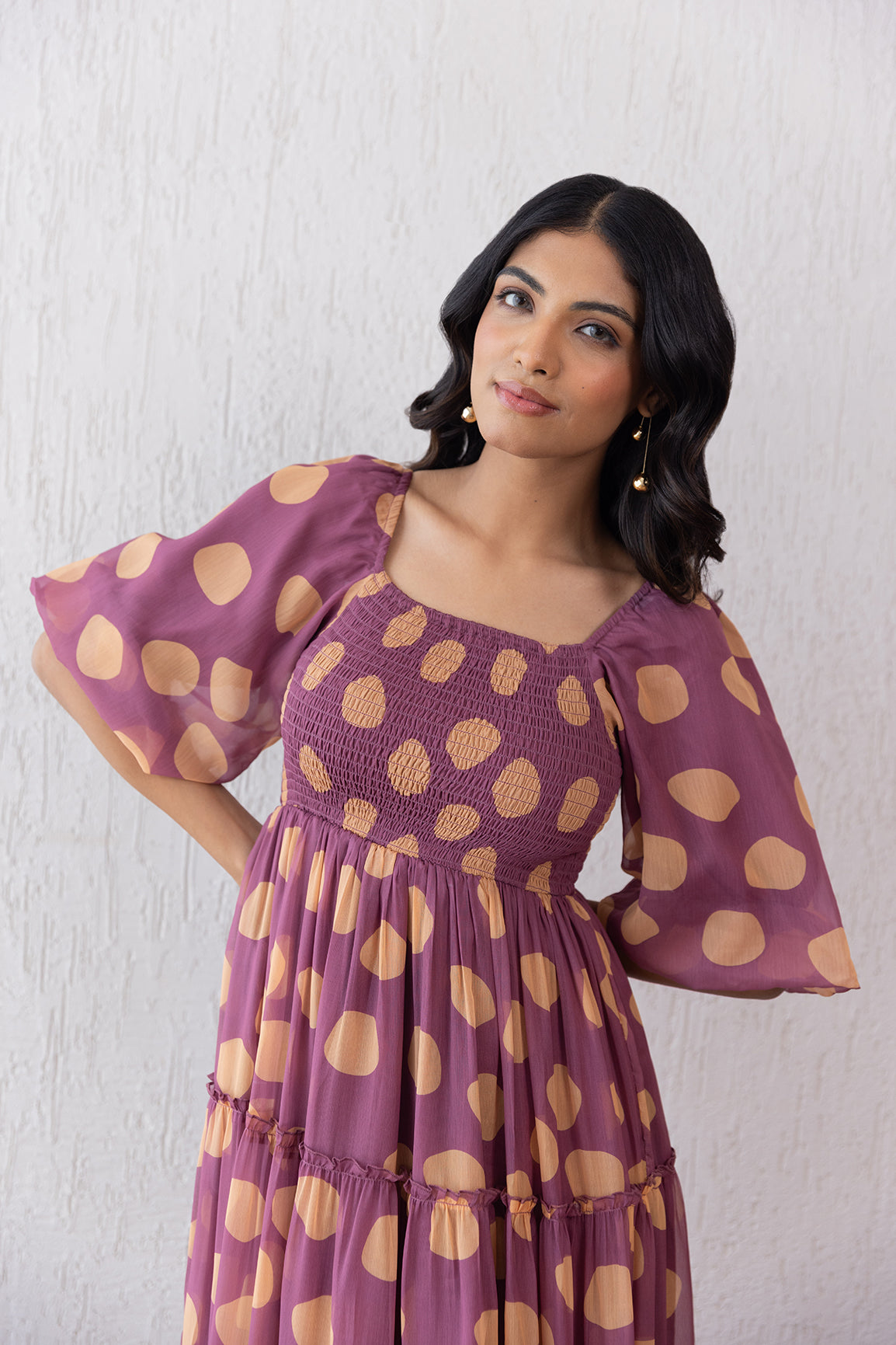 Salmon polka dot maxi dress with puff sleeves and ruffled hem.